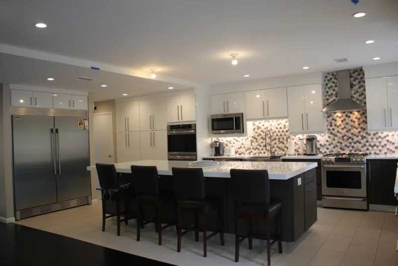 White and dark kitchen with mosaic backsplash and island seating